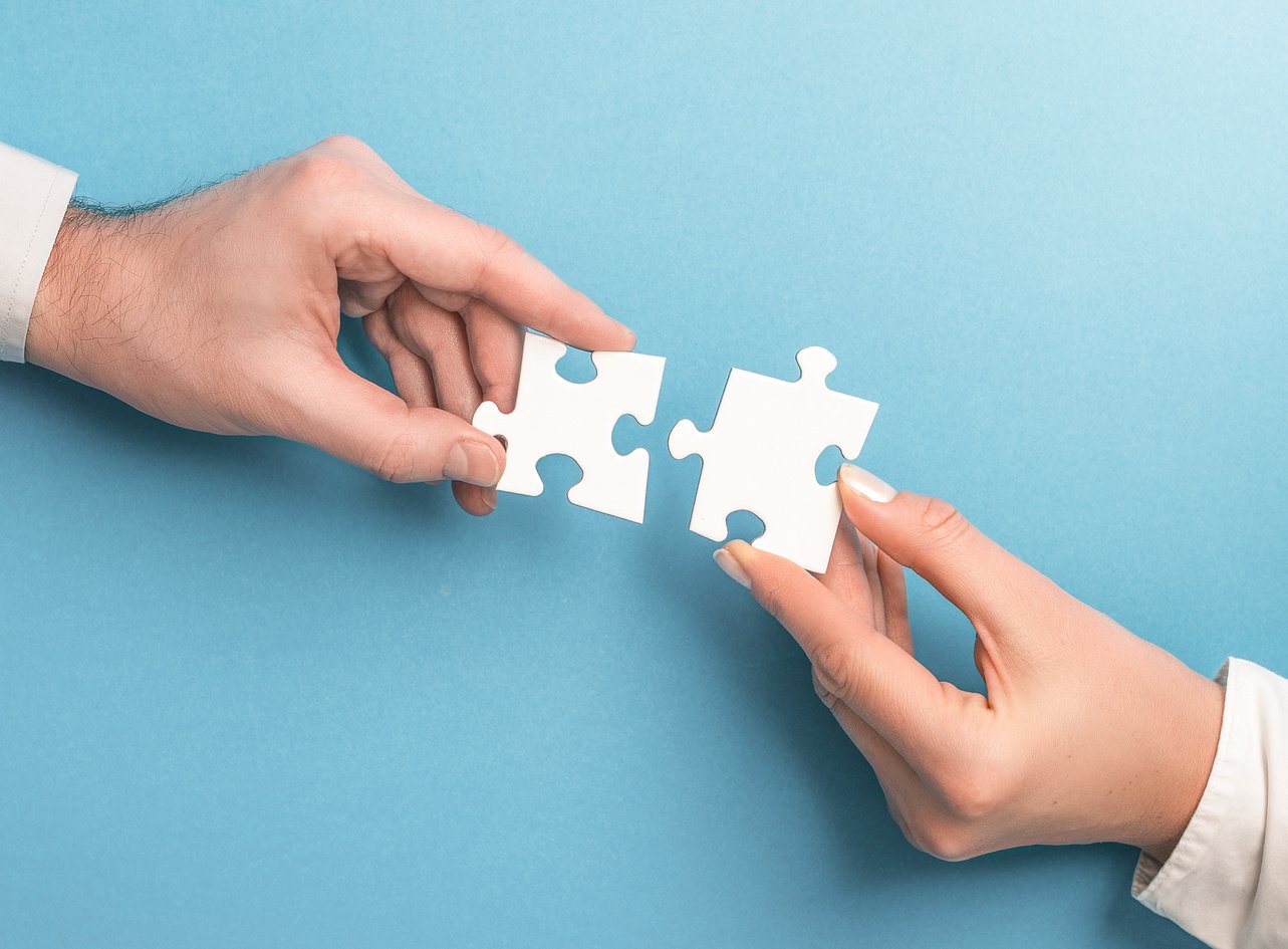 People Holds in Hand a Jigsaw Puzzle